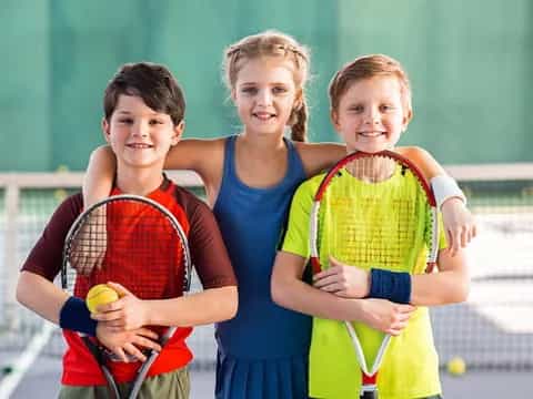 a group of kids holding tennis rackets