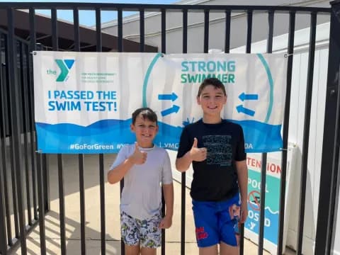 two boys standing in front of a sign