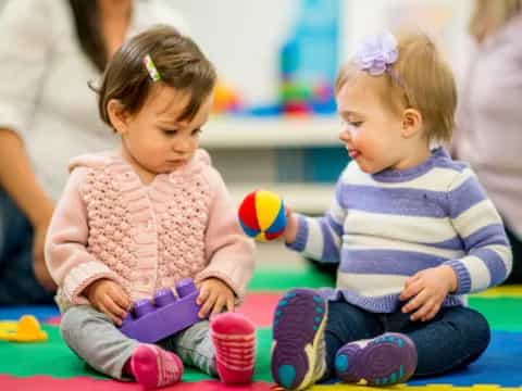 a couple of young girls sitting on the floor