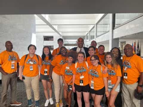 a group of people wearing orange shirts