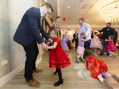 a man and a woman dancing in a room with other people