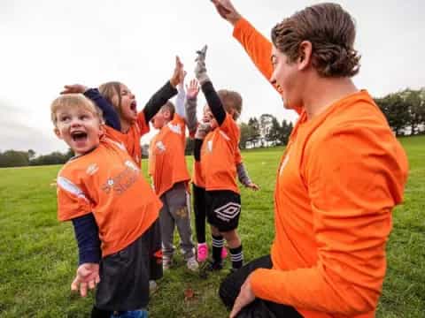 a group of kids in orange uniforms