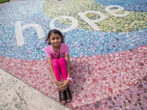 a girl sitting on a colorful floor