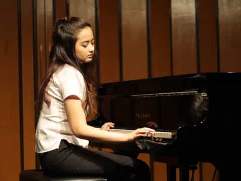 a woman playing a piano