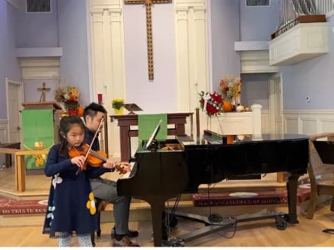 a person and a girl playing the piano