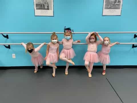 a group of girls in dresses dancing