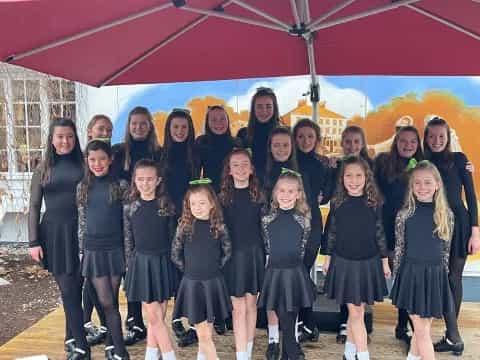 a group of girls in black and white dresses posing for a photo