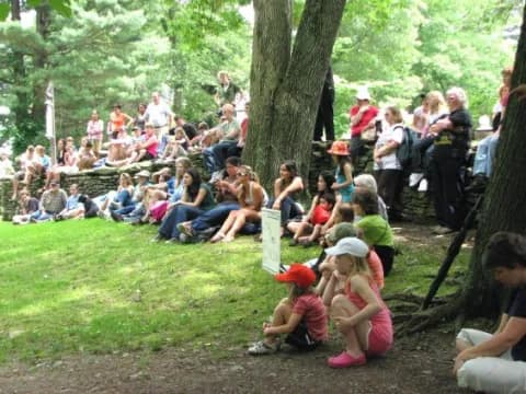a group of people sitting on the grass