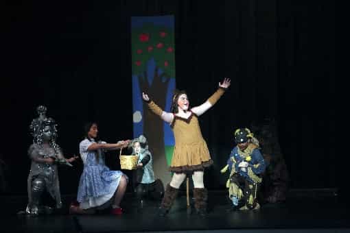 a person on stage with a group of people in clothing