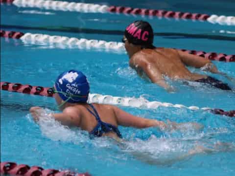 a couple of women swimming in a pool