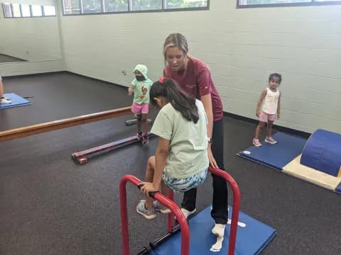 a person and a couple of children on exercise equipment