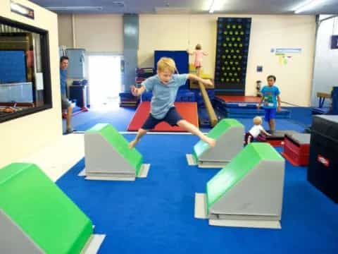 a group of kids playing on a trampoline in a room