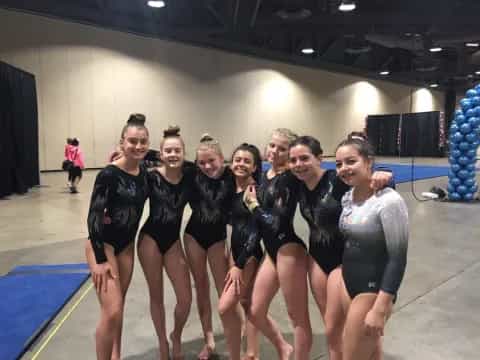 a group of women in black swimsuits posing for a photo