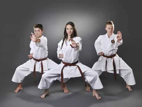 a group of people in white karate uniforms