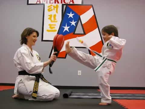 a man and a woman in karate uniforms holding a flag