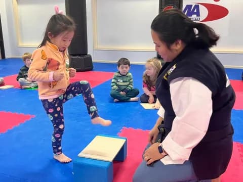 a person and a child on a mat in front of a group of children