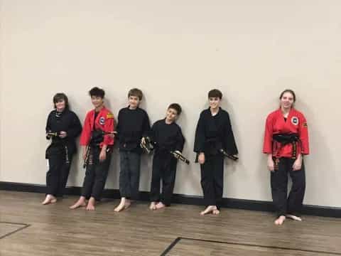 a group of people in martial arts uniforms posing for a photo