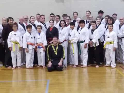a group of people in white karate uniforms posing for a photo