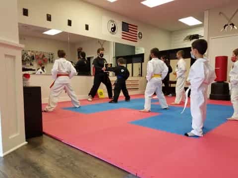 a group of people in white karate uniforms in a room