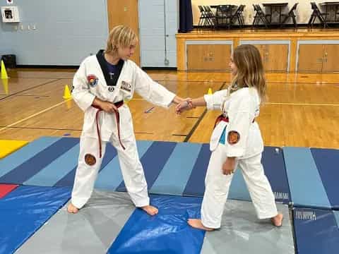 a couple of girls in karate uniforms
