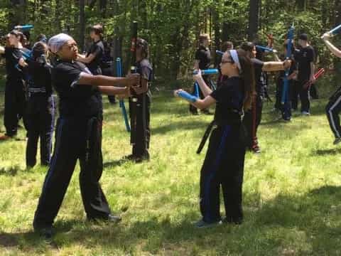 a group of people in black and blue outfits holding swords