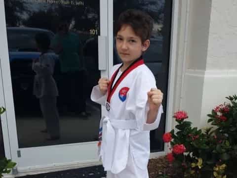 a young boy wearing a white uniform