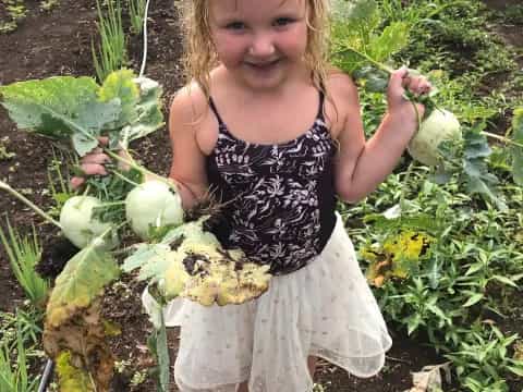 a girl holding a bunch of vegetables