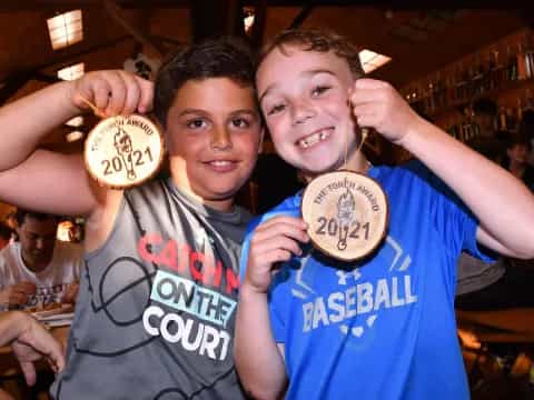 a group of boys holding up gold medals
