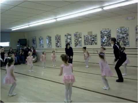 a group of people dancing in a room with pictures on the wall