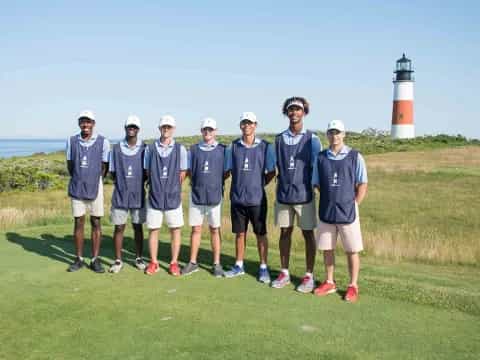 a group of men in blue shirts standing on a golf course