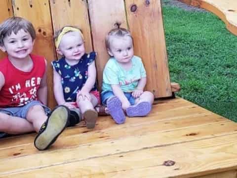 a group of children sitting in a wooden chair