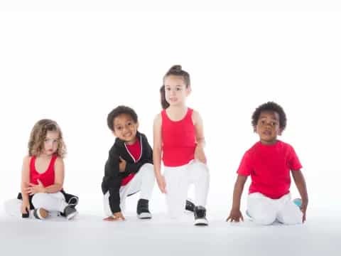a group of kids sitting and standing