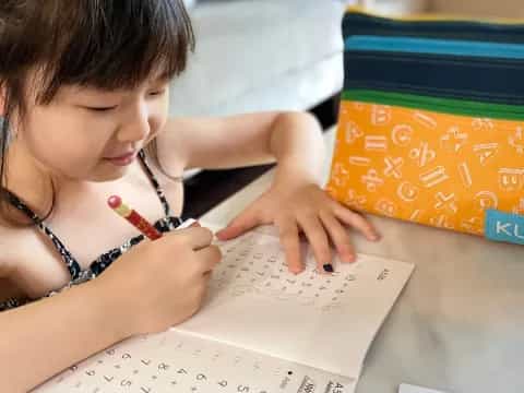 a young girl writing on a piece of paper
