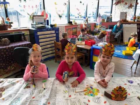 a group of children sitting at a table with a cake