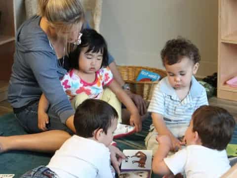 a person and several children sitting on the floor