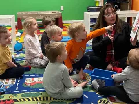 a person and several children sitting on the floor