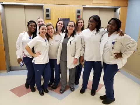 a group of women in white lab coats