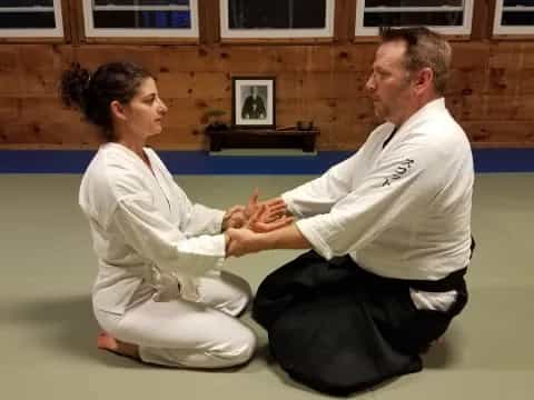 a man and a woman in karate uniforms sitting on the floor