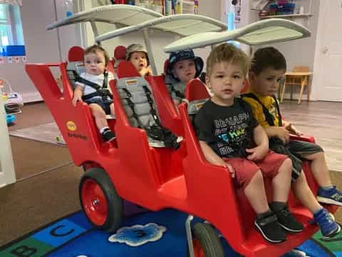 a group of kids sitting in a toy car