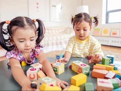 a couple of children playing with blocks