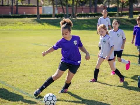 a group of girls compete over a football ball