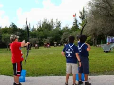 a group of boys playing with a bow and arrow