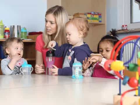 a person and two children sitting at a table with a toy