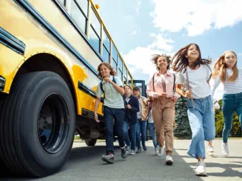 a group of people walking next to a yellow school bus