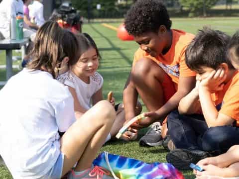 a group of children sitting on the grass