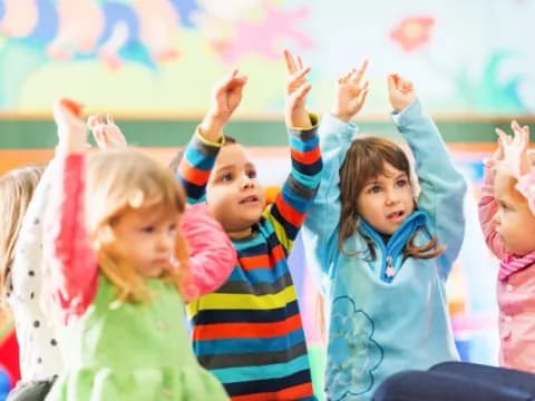a group of children raising their hands