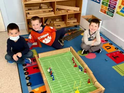 a group of kids sitting on the floor playing a board game