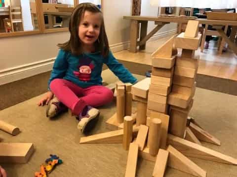 a girl sitting on a wooden structure
