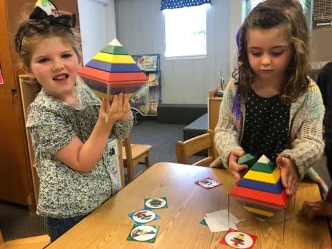 a couple of young girls playing with toys on a table