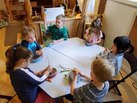 a group of children sitting around a table eating food